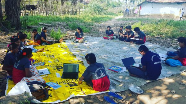 A group of children are studying, reading, and working together in a circle