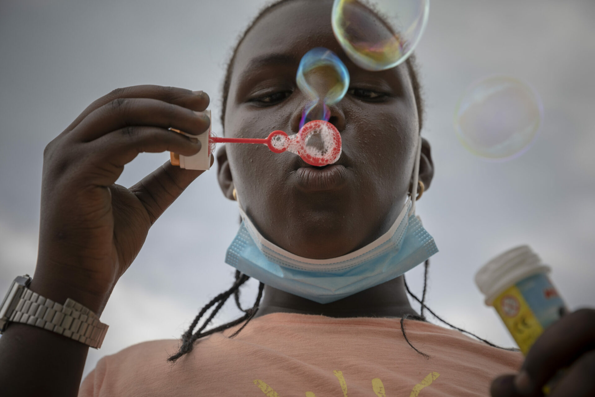 A closeup of a boy blowing bubbles