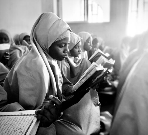 Several girls are seen studying and reading in a room together.