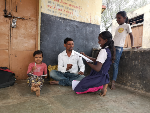 During the pandemic, a Banjara facilitator conducts Anandshala, an informal neighborhood school, outside a padlocked school in India.