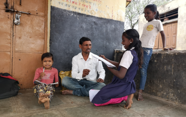 During the pandemic, a Banjara facilitator conducts Anandshala, an informal neighborhood school, outside a padlocked school in India.