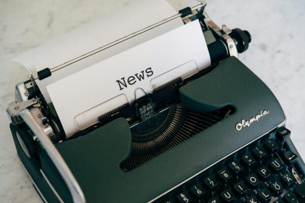 vintage Olympia typewriter with a paper that reads News