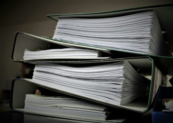 stack of binders filled with paper