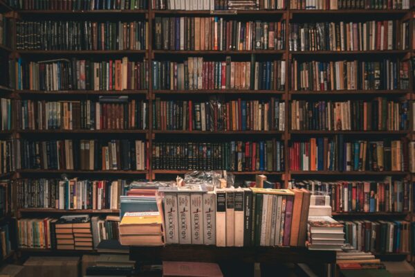 books stacked on table and rows at library